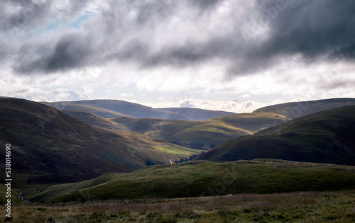 Early morning sun trying to break through the cloud over Coquetdale, the Cheviot Hills in Northumberland, England, UK.