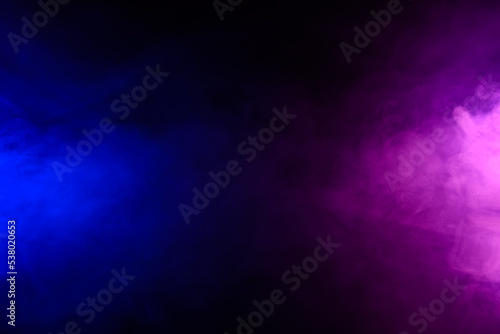 Smoke clouds in blue and purple neon light swirling on black table background with reflection