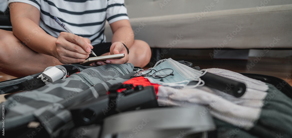 Asian man is preparing clothes in suitcases Asian man is preparing clothes in suitcases