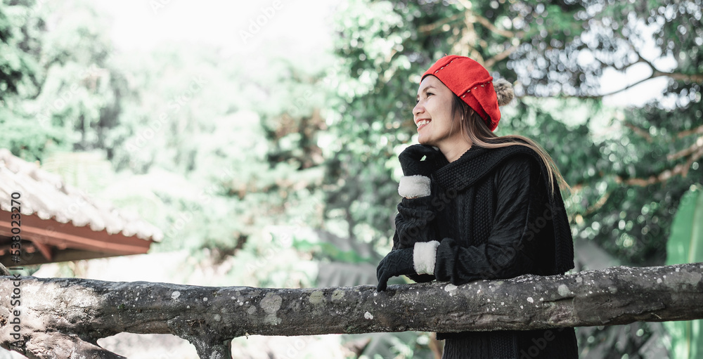 Portrait of Happy Asian young woman in winter costume at the forest with copy space Portrait of Happy Asian young woman in winter costume at the forest with copy space