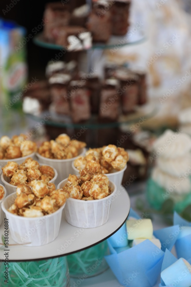 Cups with delicious caramel popcorn on dessert stand Cups with delicious caramel popcorn on dessert stand