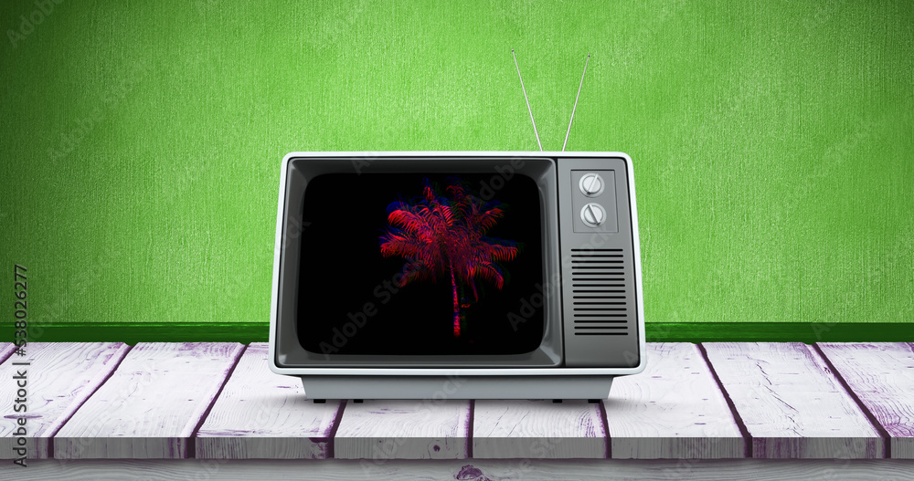 Obraz premium Composite of palm tree in television set over wooden table against green background, copy space
