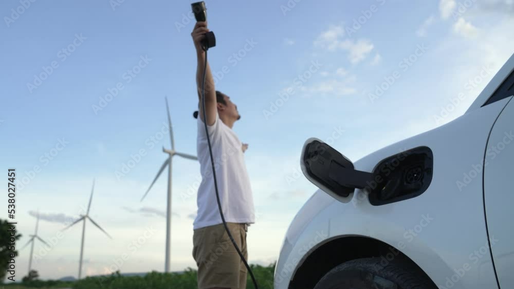 Progressive man with his electric car, EV car recharging energy from