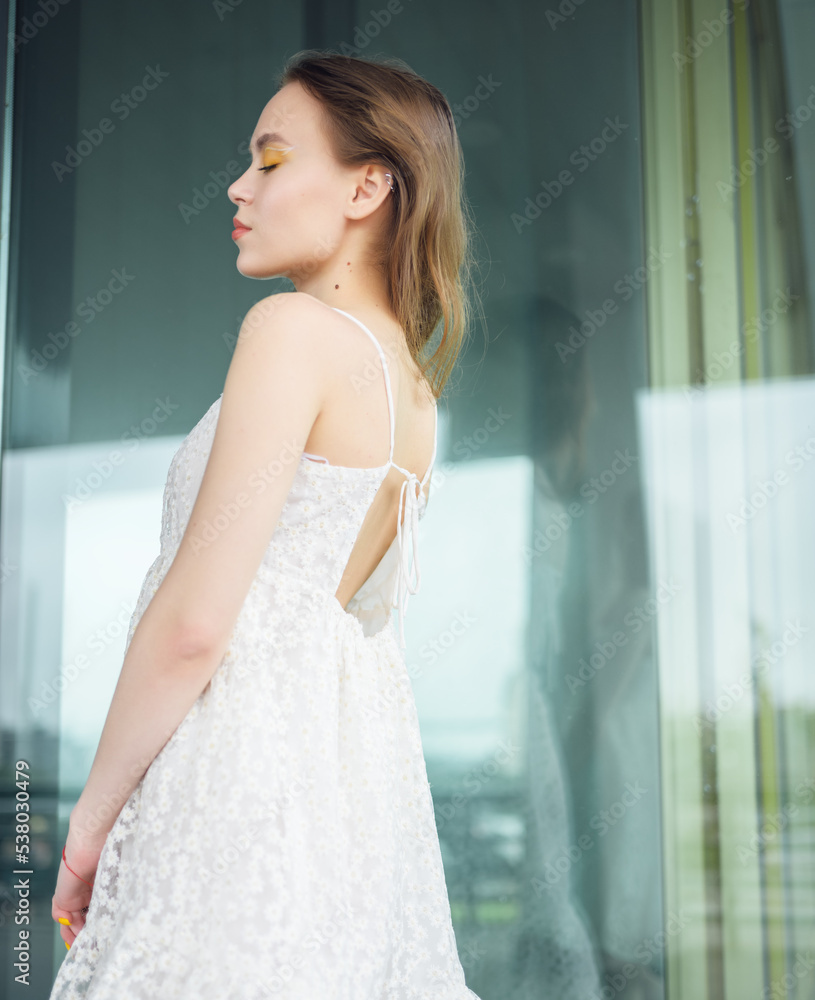City portrait of beautiful young woman in white dress. City portrait of beautiful young woman in white dress.