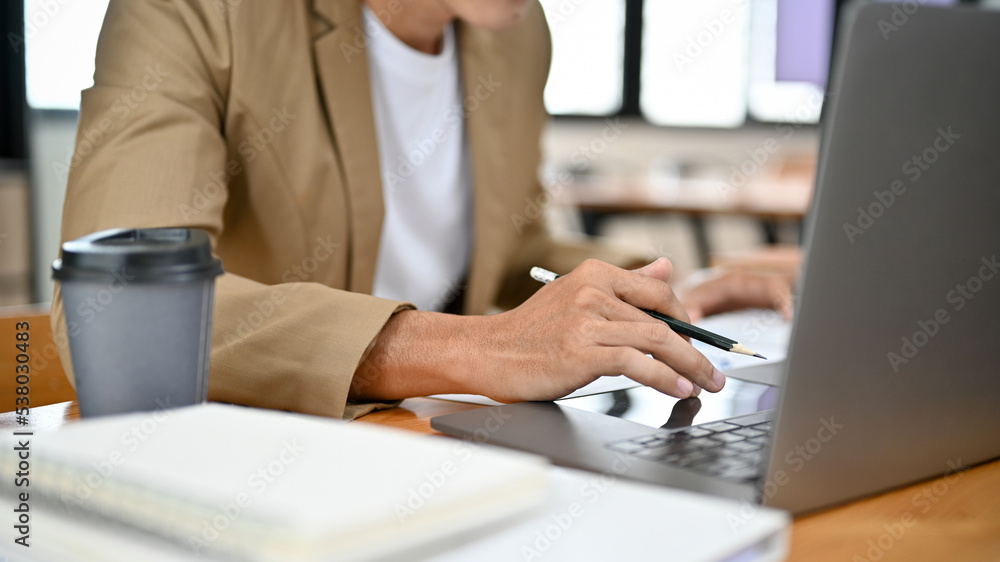 Smart Asian businessman or male boss working at his office desk, using laptop. cropped Smart Asian businessman or male boss working at his office desk, using laptop. cropped