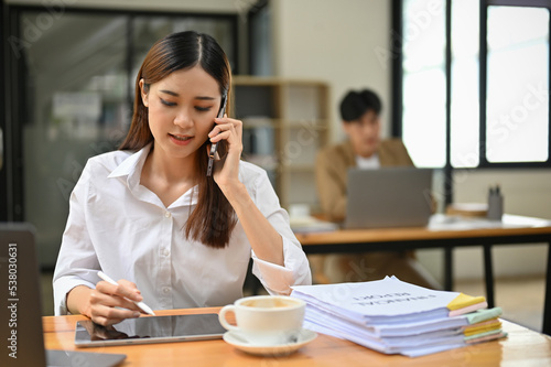 Professional Asian businesswoman focused on a call with her client in the office.