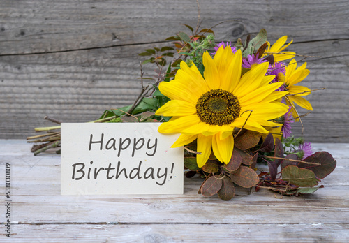 Canvas Print Birthday card with the English text: Happy Birthday is in front of an autumn bouquet with sunflowers