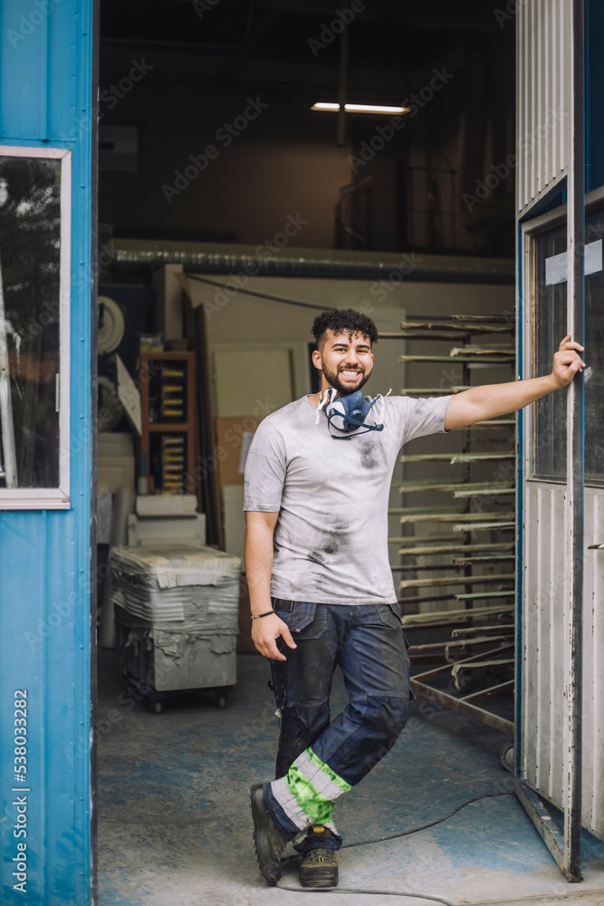 Full length portrait of smiling male painter standing at doorway Full length portrait of smiling male painter standing at doorway
