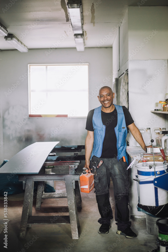Full length portrait of smiling male painter in workshop Full length portrait of smiling male painter in workshop