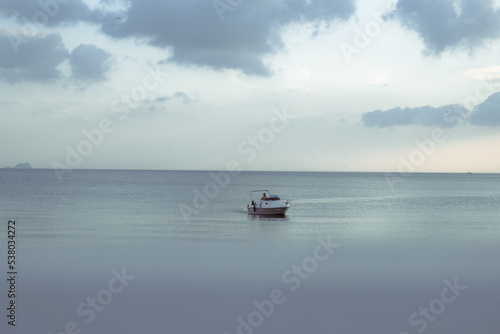 a beautiful sea and a fast white boat on it.