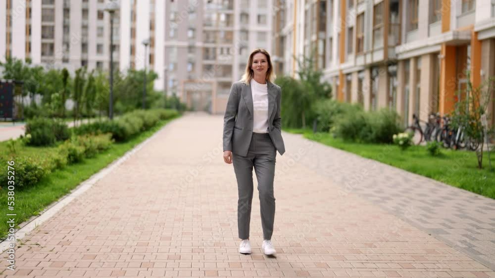 woman is walking in city center in summer or spring, full-length portrait, following shot, rear view woman is walking in city center in summer or spring, full-length portrait, following shot, rear view