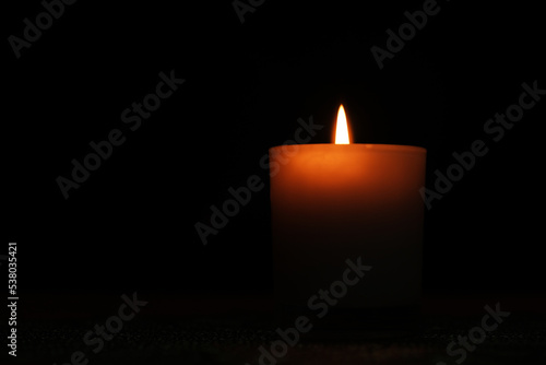 white candle light in the dark, grieving concept