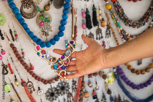 Hand of young tourist woman trying on necklaces, bracelets and other jewelry in Marrakech is an ancient imperial city in western Morocco.