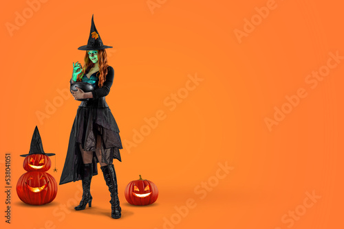Witch on Halloween. Female wizard fairy character for All Saints' Day. Fantasy gothic red-haired Vampire girl in black dress. Enchantress dressed in carnival costume