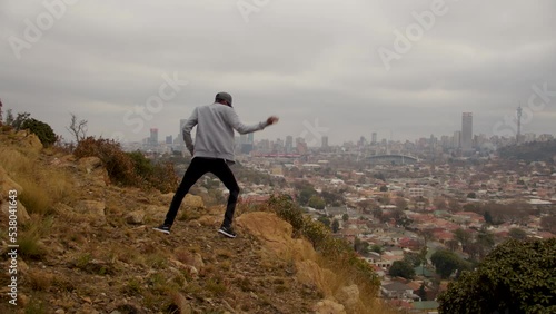 African Hip-hop dancer on a hill overlooking Johannesburg City photo