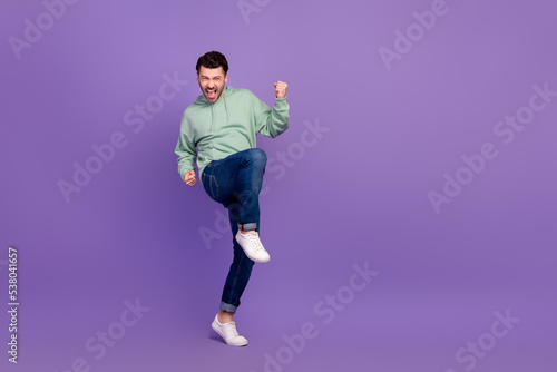 Full body size photo of young successful businessman wear stylish outfit fists up enjoy crazy empty space new tournament isolated on violet color background © deagreez