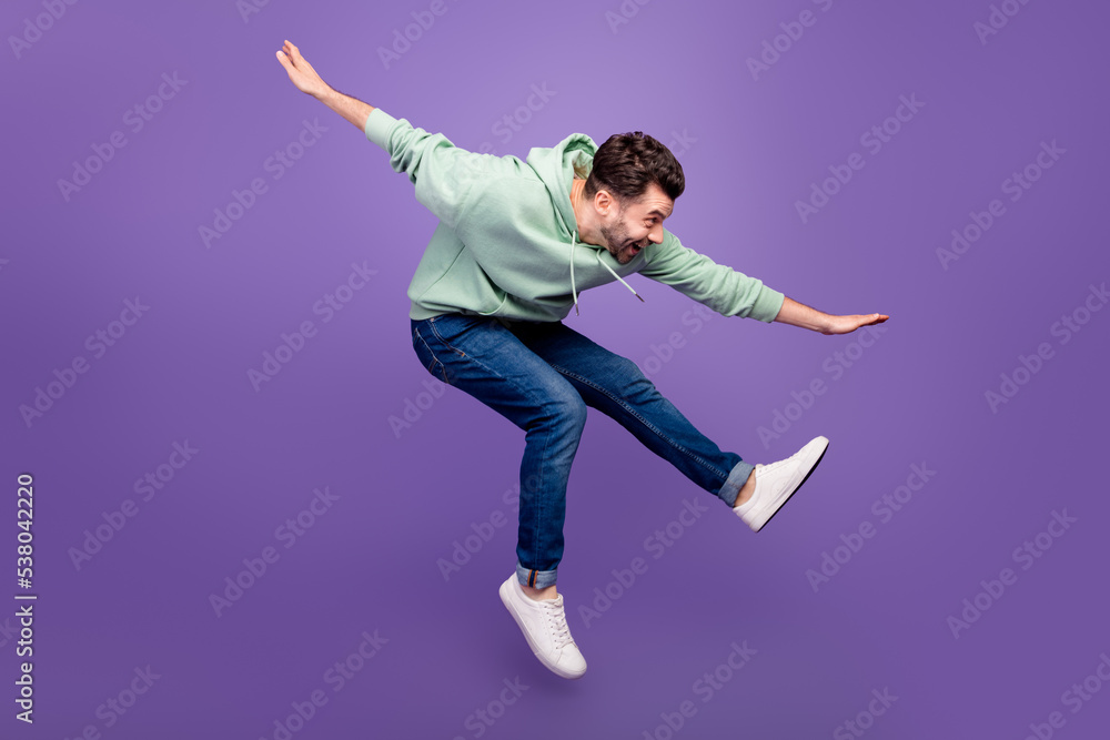 Full body profile photo of energetic cheerful man jumping have fun isolated on violet color background