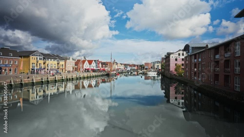 Panoramic View of Husum Harbor in Germany.  Clouds movement time lapse reflected in still water - zoom out motion photo