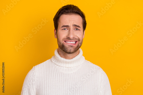 Photo of nervous horrified guy bite lip anticipate problems wear white knitted sweater isolated yellow color background