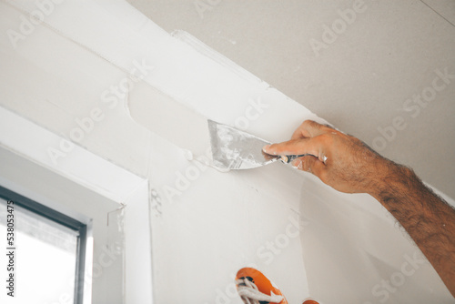 Tableau sur toile Plastering wall with putty-knife, close up image.