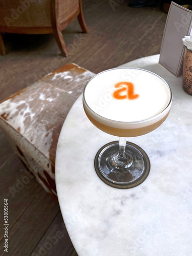 Fresh cocktail glass with orange letter A in restaurant
