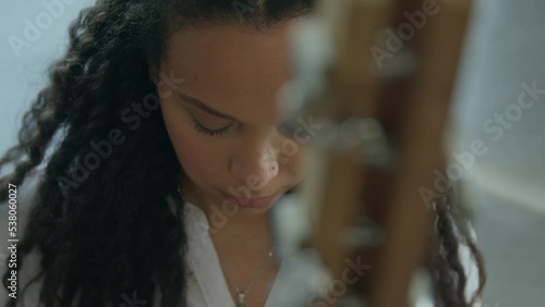 girl playing Kora strings percussion African harp in a warm daylight ambient, close-ups shot photo