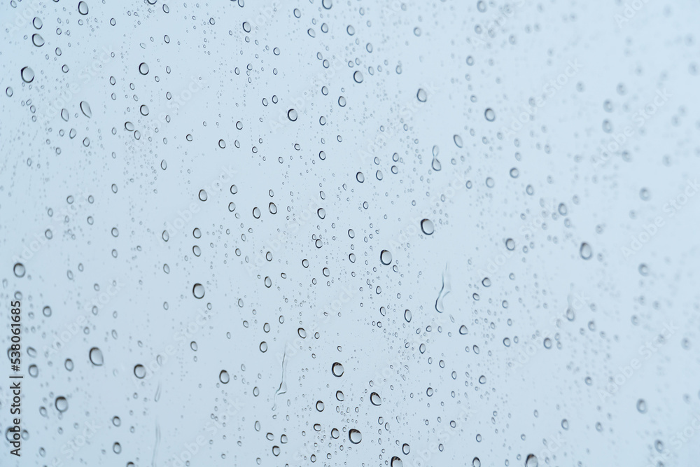 Raindrops on a window on a rainy day - rain concept, textures and patterns Raindrops on a window on a rainy day - rain concept, textures and patterns