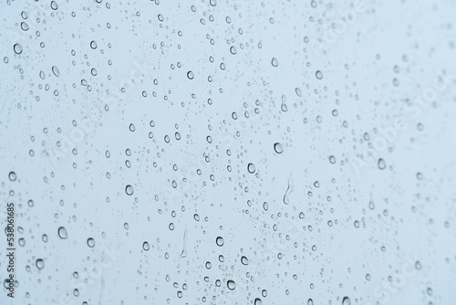 Raindrops on a window on a rainy day - rain concept, textures and patterns