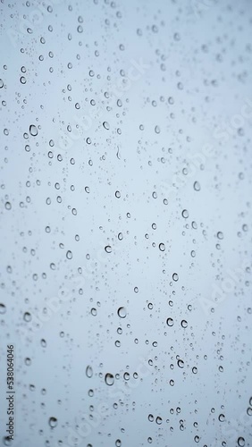 Raindrops on a window on a rainy day - rain concept, textures and patterns