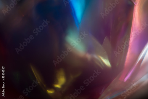 Abstract light background. Defocused abstract background of transparent synthetic flowers with rgb light highlight. blue, purple, yellow and gold gradations on a dark background.