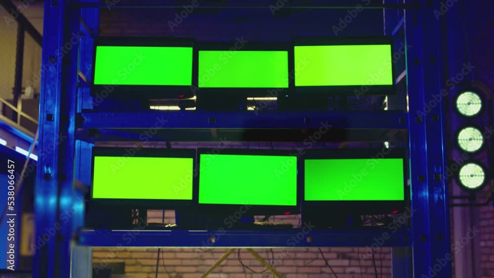 A lot of monitors with green screen in dark modern room. Concept of monitoring , trading , analysing room and security systems . Video Switcher , many Screens for Broadcasting Live at Tv Control place