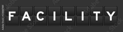 Black color analog flip board with word facility on gray background