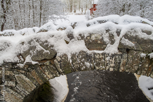 Old arch bridge over a river in the winter