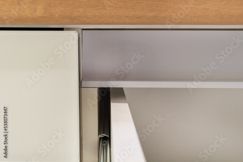 Metal handle profile and roller stainless guide or rail for drawers with a closer. Close-up on a white background. photo