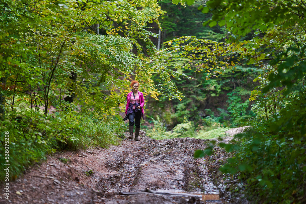Nature photographer lady hiking in the forest