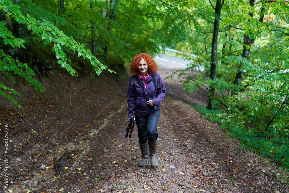Hiker lady with camera in the mountain forest Hiker lady with camera in the mountain forest