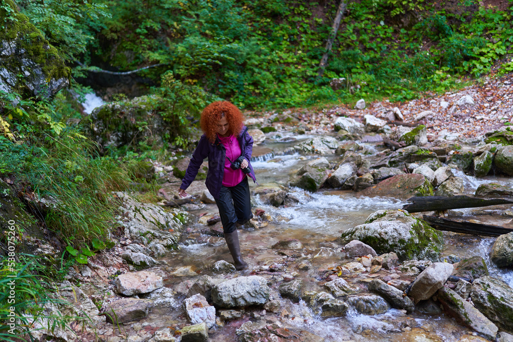 Hiker lady with camera in the mountain forest Hiker lady with camera in the mountain forest
