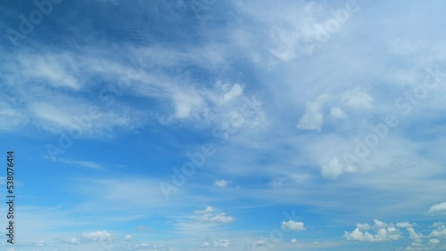 Dramatic moving white cumulus and cirrocumulus clouds or puffy fluffy cloudscape on beautiful sunny blue sky. Timelapse.