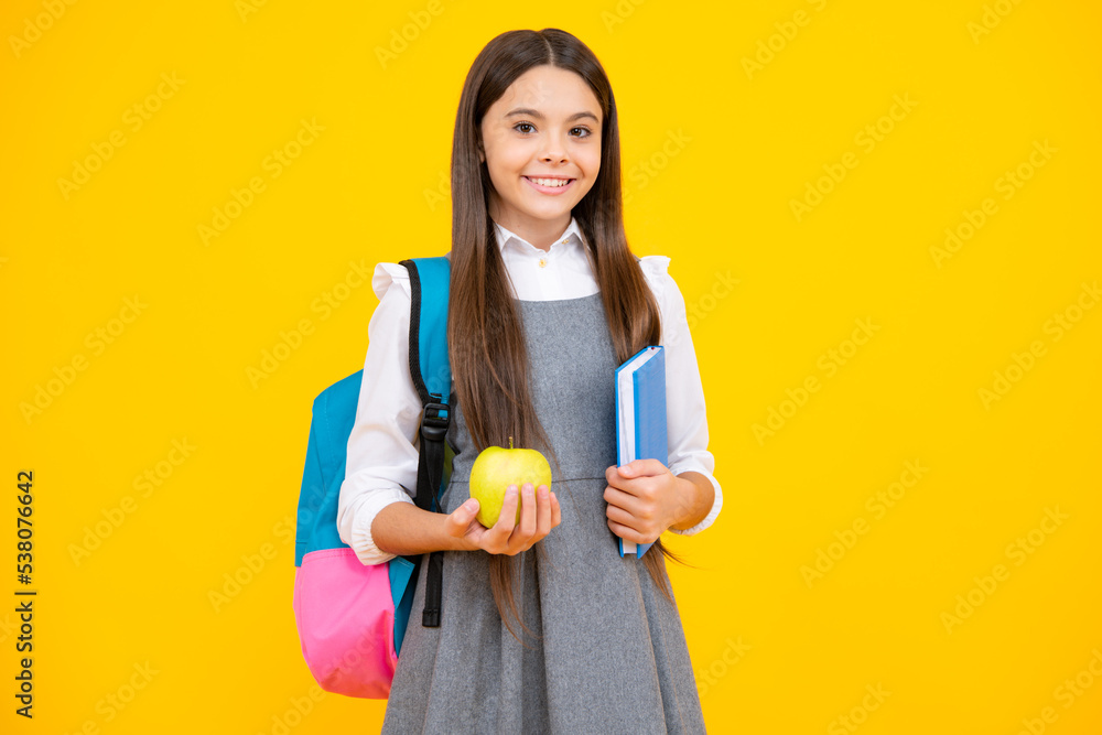 Back to school. Teenager schoolgirl hold book and copybook ready to learn. School children on isolated yellow studio background. Back to school. Teenager schoolgirl hold book and copybook ready to learn. School children on isolated yellow studio background.