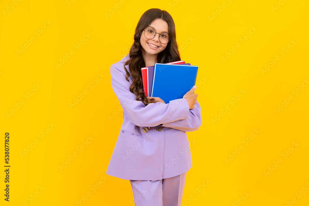 Back to school. Teenager schoolgirl with book ready to learn. School girl children on isolated yellow studio background. Back to school. Teenager schoolgirl with book ready to learn. School girl children on isolated yellow studio background.