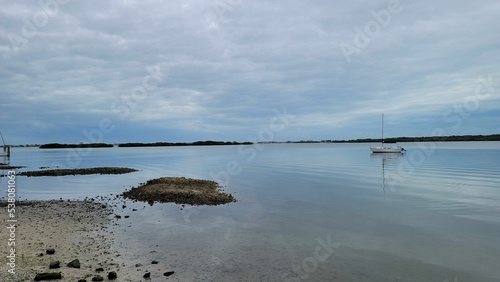 Isolated boat in a blue sea under a cloudy sky in Abercrombie Park, Florida photo