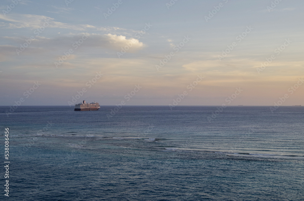 Modern HAL cruiseship or cruise ship liner Koningsdam sail away departure from port during Caribbean cruising dream vacation twilight blue hour sunset seascape landscape scenery
