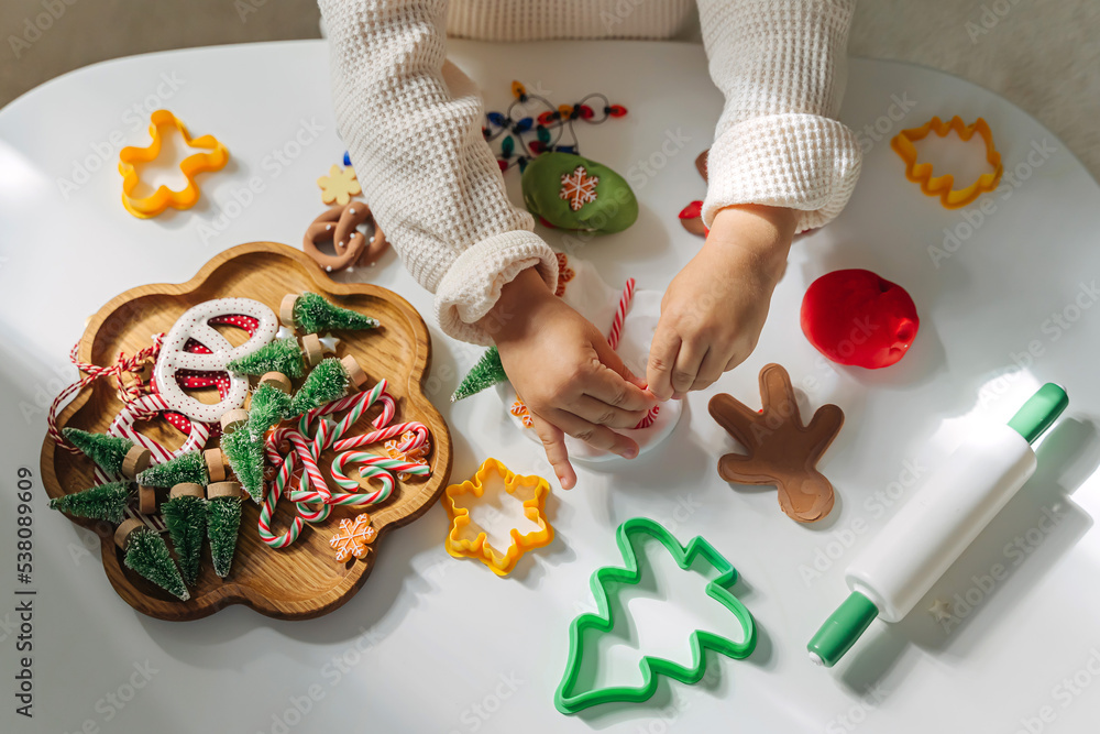 Child hands creating Christmas crafts. Child playing with play dough