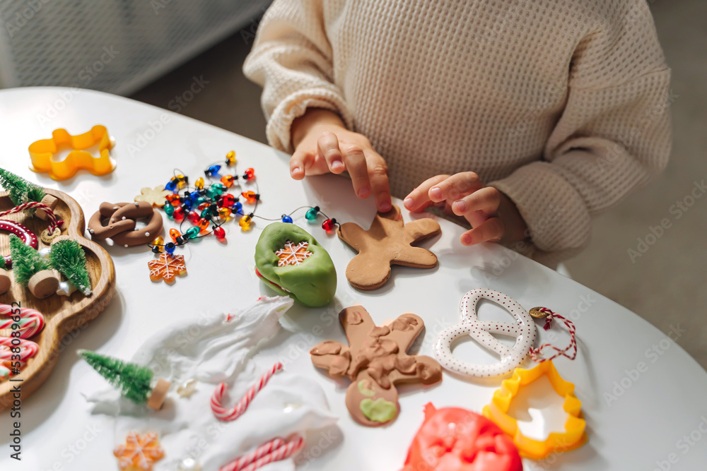 Child hands creating Christmas crafts. Child playing with play dough
