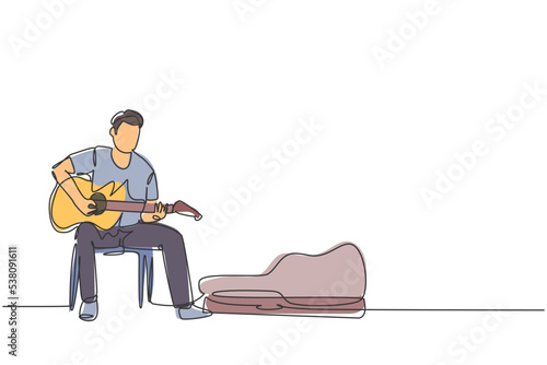 One continuous line drawing of young happy male guitarist sitting and busking by playing guitar on uptown road. Street musician artist performance concept single line draw design vector illustration photo
