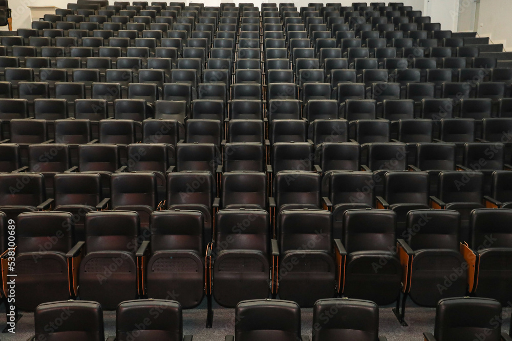 Obraz premium Theater auditorium with emphasis on the black chairs and wooden sides, all the same giving continuity and lines.