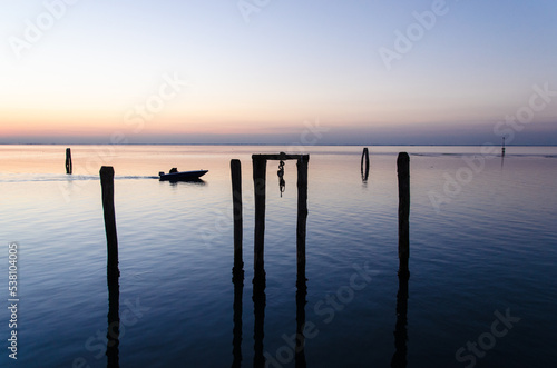 Un motoscafo naviga veloce nella laguna di Venezia, a Pellestrina, al crepudscolo