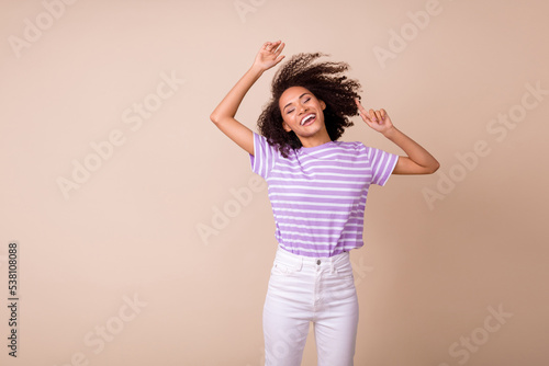 Photo of cool adorable lady wear violet t-shirt having fun dancing empty space isolated beige color background