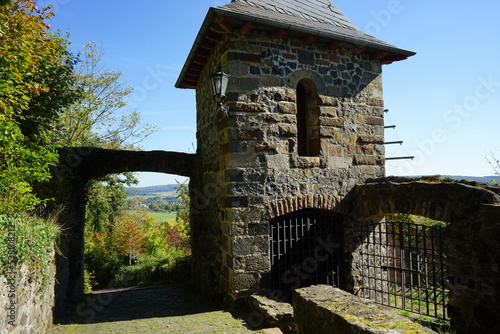 Alter Wehrturm mit Eingangsportal der Burgruine Staufenberg vor blauem Himmel im Sonnenschein im Herbst in Staufenberg im Kreis Gießen in Hessen photo