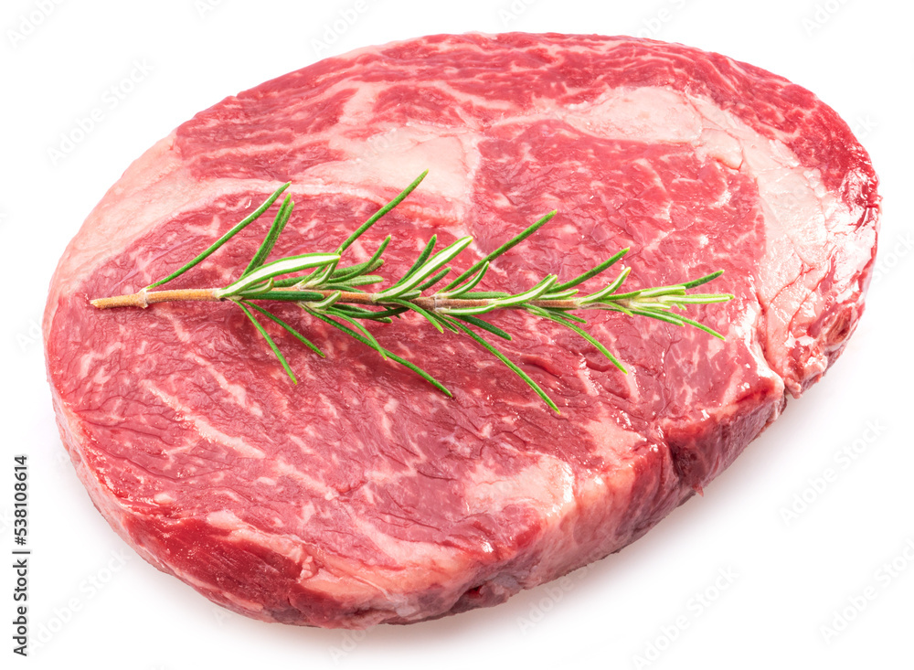 Raw ribeye steak with rosemary twig on it on white background. Top view.